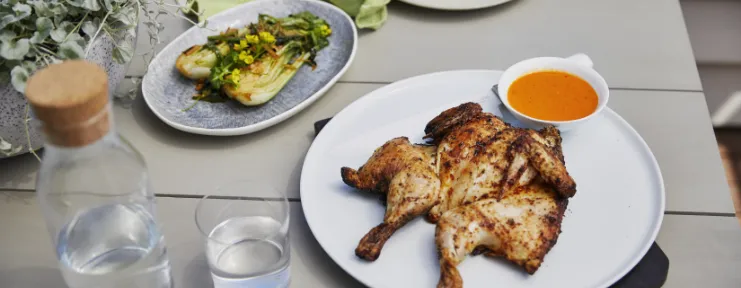 Set table with grilled chicken and vegetables