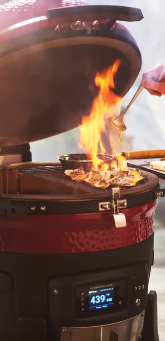 Kamado Joe Grill auf dem gerade Grillgut flambiert wird