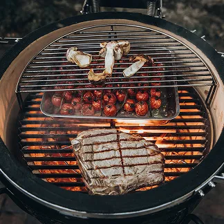 Reichlich mit Grillgut bestückter offener Monolith Grill