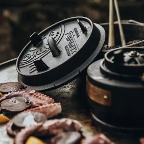 Two open drawers of a Monolith grill containing accessories