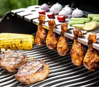 Close-up of a grill grate abundantly loaded with meat and vegetables